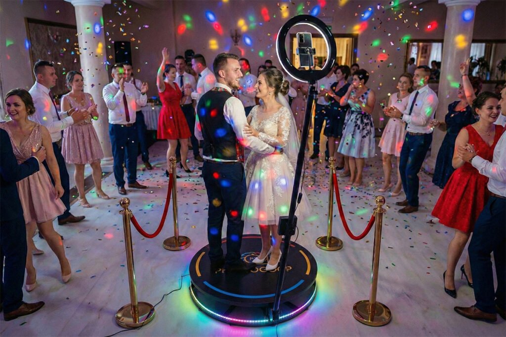 360 fokos videóplatform esküvőn – ifjú pár forog a platformon konfettivel és RGB fényekkel körülvéve